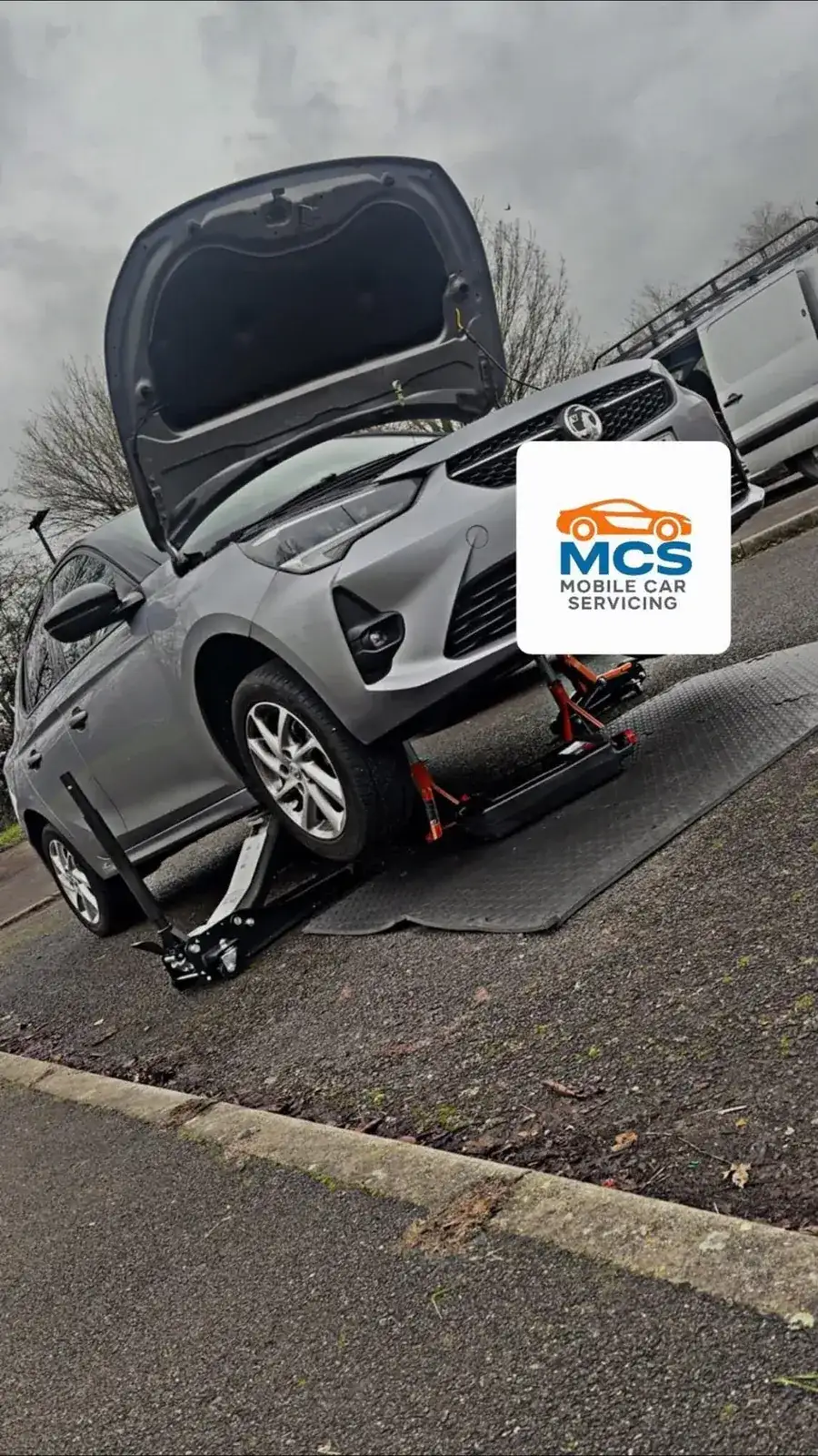 Vauxhall Corsa raised on a ramp with new brake discs and pads ready to fit