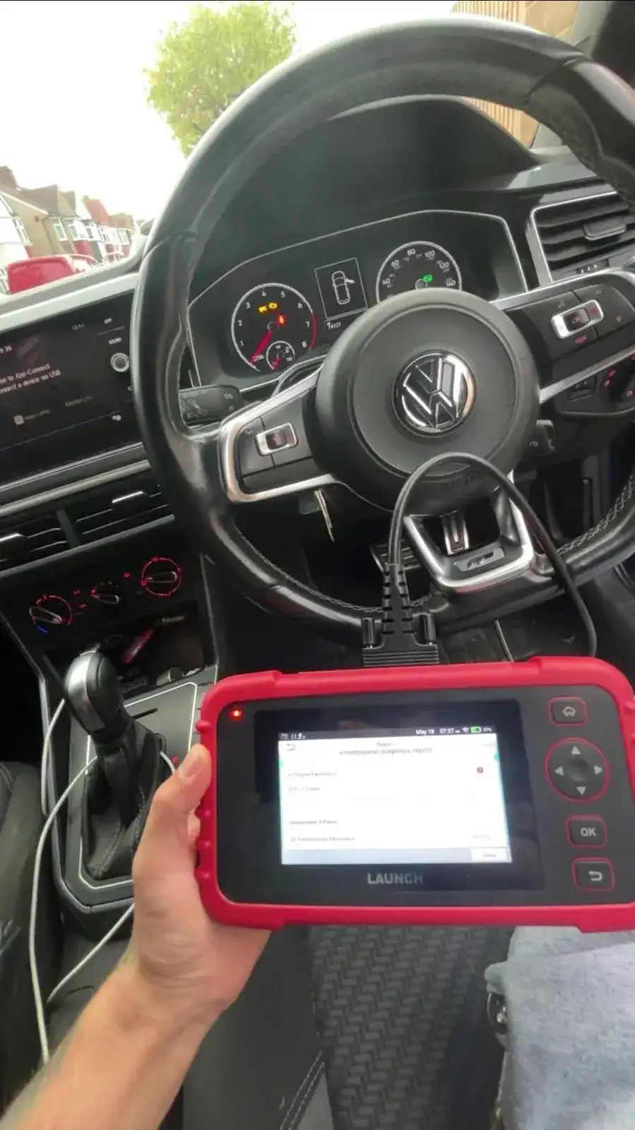 Professional diagnostic scanner plugged into a Volkswagen's OBD port