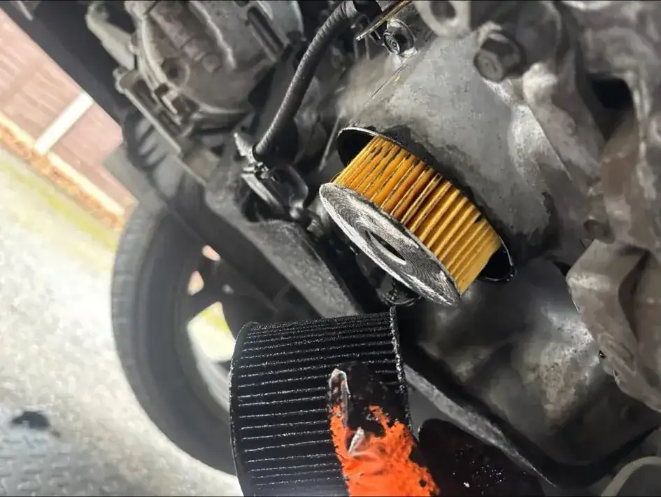 Close-up of an oil filter being removed from an engine