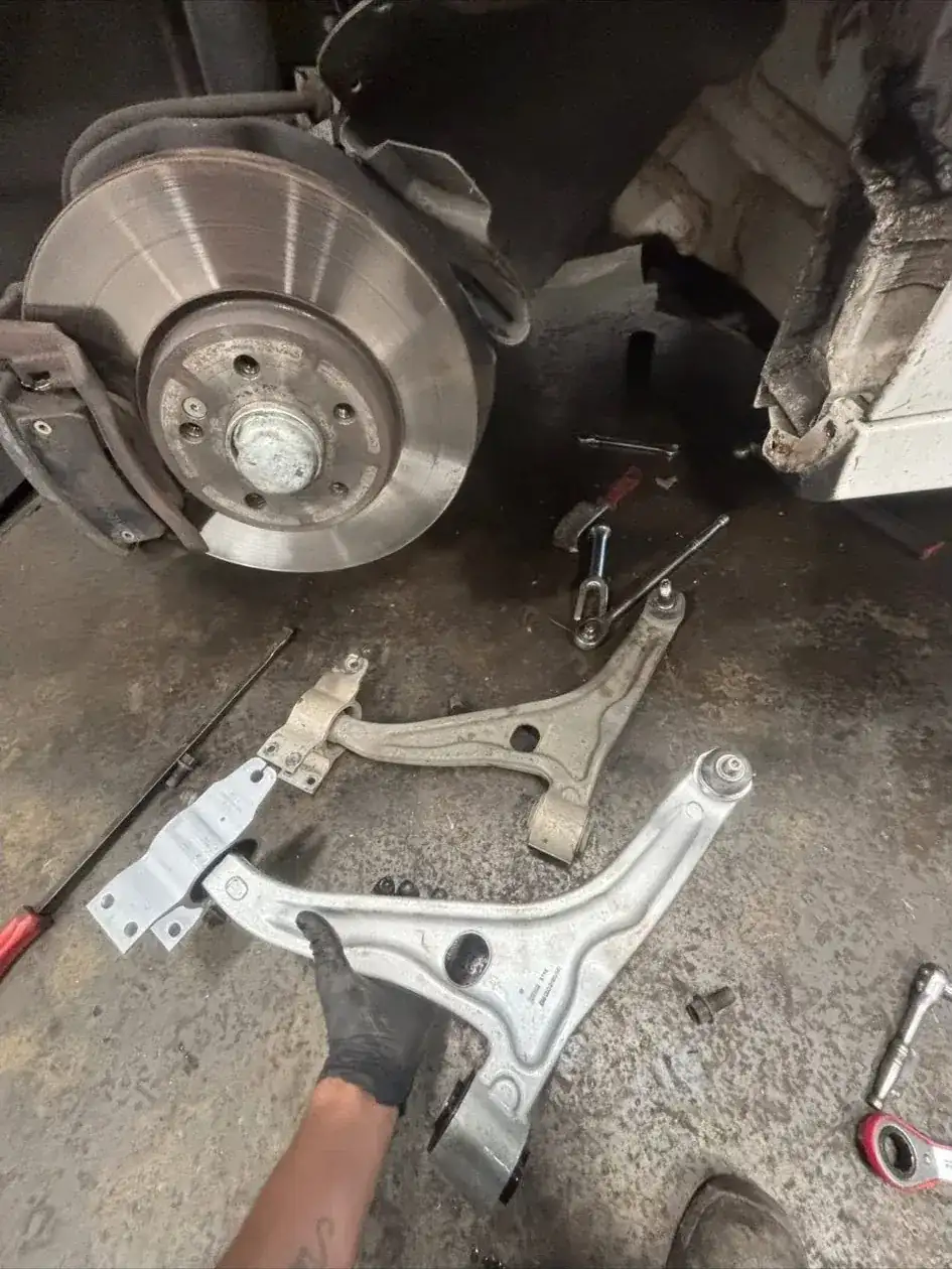 Suspension control arms removed from a car during a mobile suspension repair