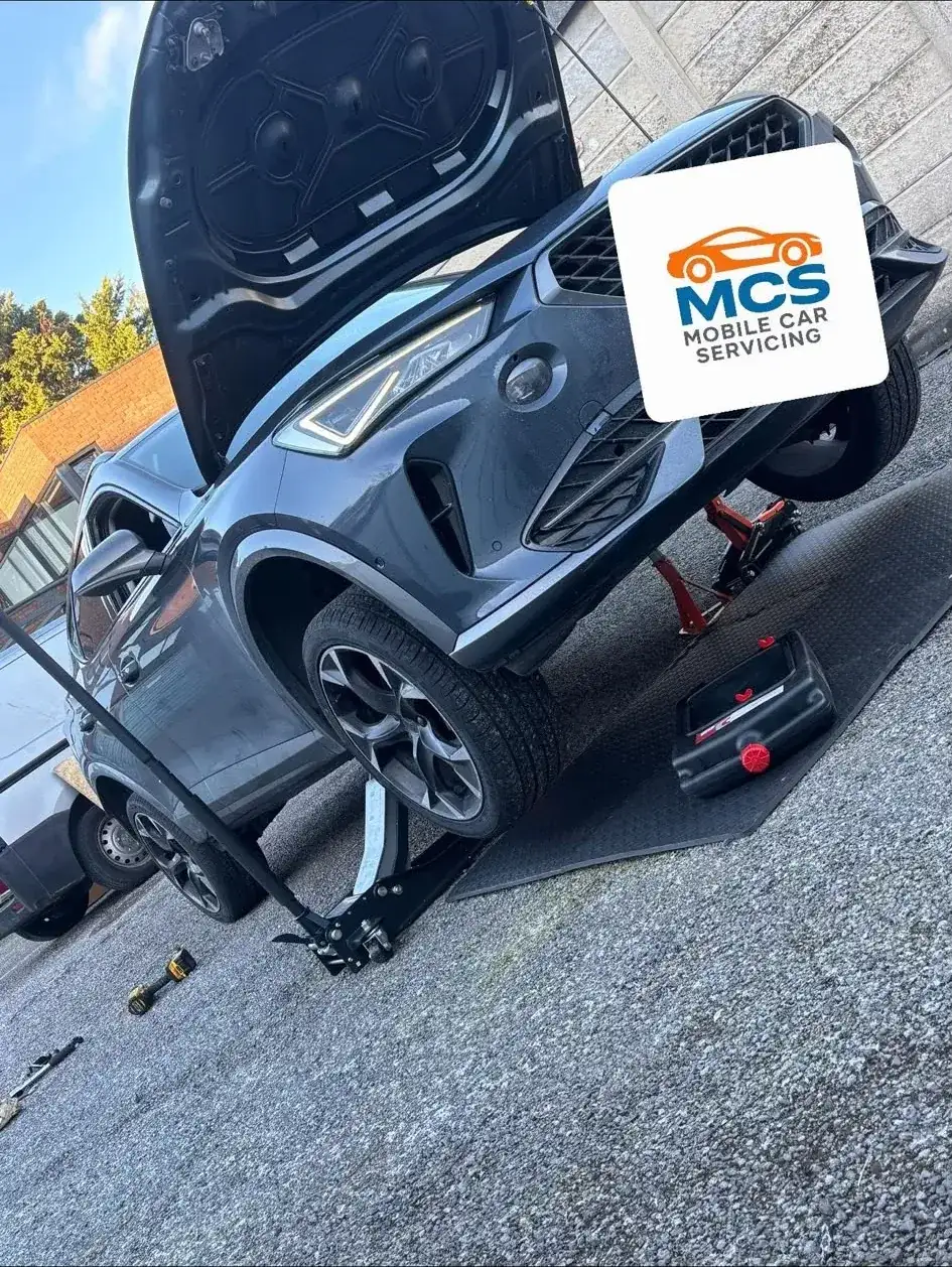 SUV raised on a ramp outside a house during a mobile service