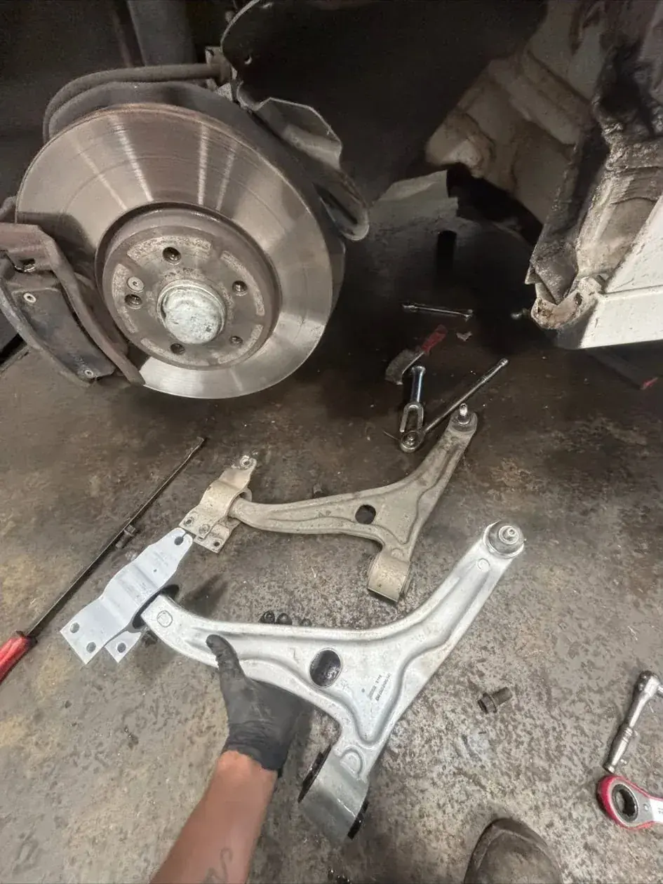 Suspension control arms removed from a car during a mobile suspension repair